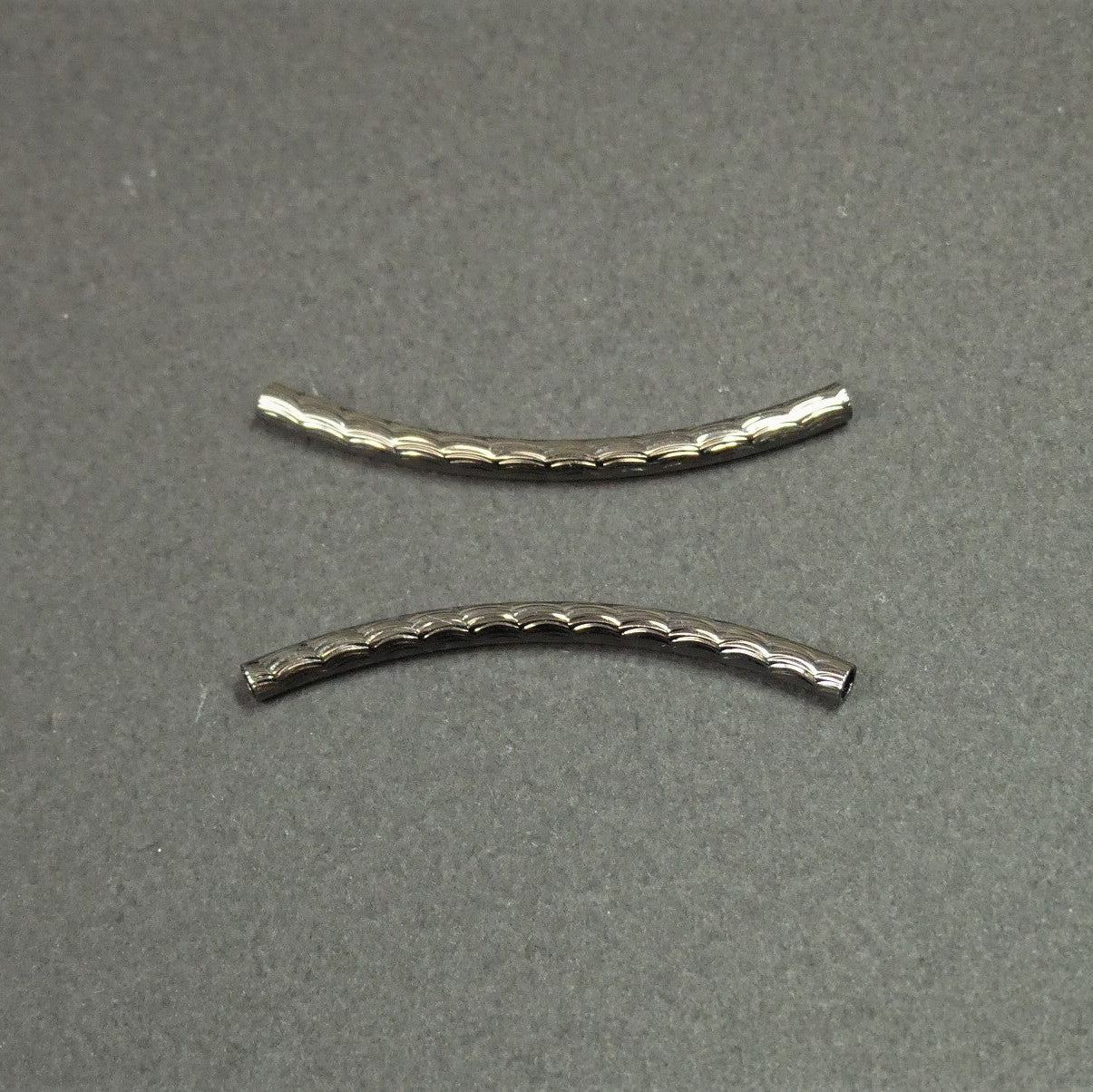 Perles tubulaires courbé à facette - Couleur: Antharcite ( 2 pièces)